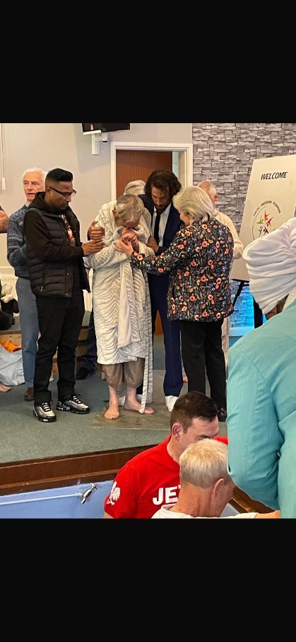 A resident being supported by family and Tranquil Minds staff at his baptism ceremony.