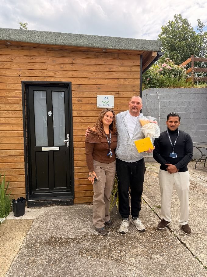 Stephen celebrating a recovery milestone with two Tranquil Minds support workers outside his home.